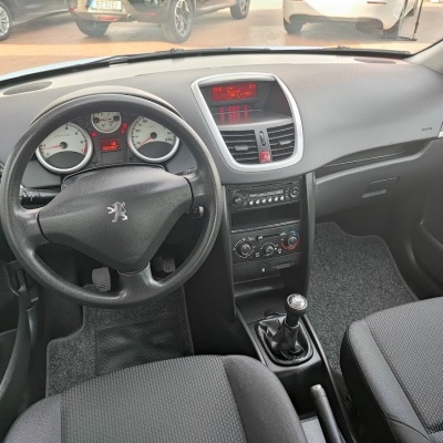 Interior de carro Peugeot com volante em couro preto e painel cinza