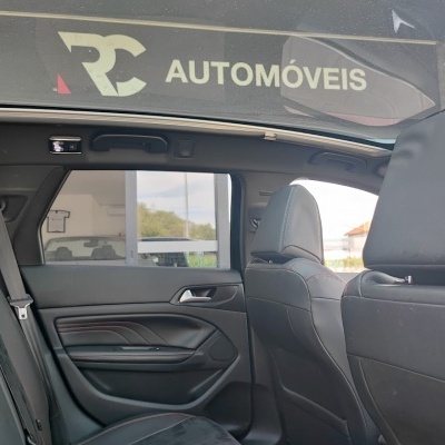 Interior de carro com bancos de pele preta e teto panorâmico.