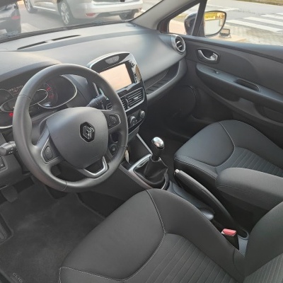 Interior de carro Renault Clio com volante, bancos e painel