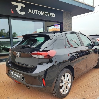 Carro Opel Corsa preto estacionado em loja RC Automóveis