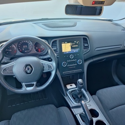 Interior de carro Renault com volante, painel digital, ecrã tátil e bancos em tecido cinzento