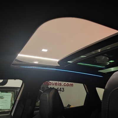 Interior de carro com teto solar aberto e iluminação azul