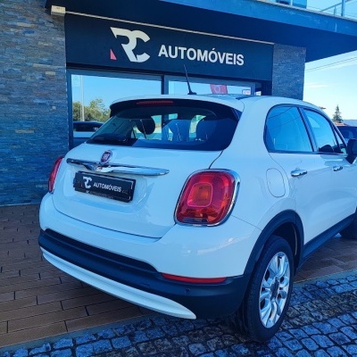 Fiat 500X branco estacionado em frente a loja RC AUTOMÓVEIS