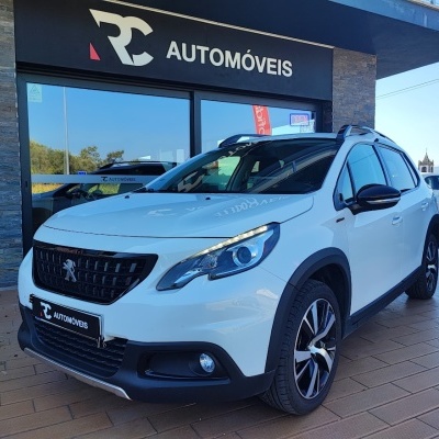 Carro Peugeot branco estacionado em frente à loja RC AUTOMÓVEIS