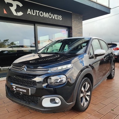 Carro Citroën preto com detalhes brancos em frente à loja RC AUTOMÓVEIS