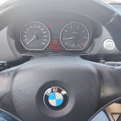 Volante de carro BMW preto com painel de instrumentos e botão START ENGINE