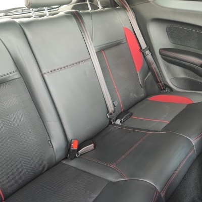 Assento traseiro de carro preto e vermelho com cintos de segurança