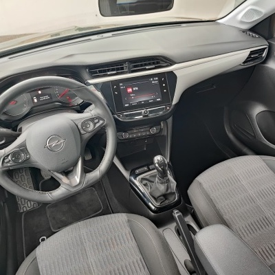 Interior preto e cinza de carro Opel com volante, painel e banco de tecido.