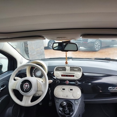 Interior de carro Fiat 500 com volante branco e painel preto e branco