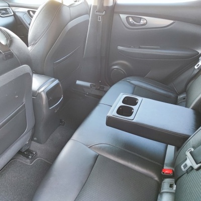 Interior traseiro de automóvel com bancos em couro preto e apoio de braço