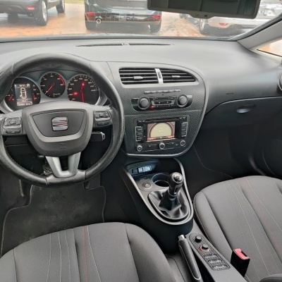 Interior de automóvel com volante preto e consola central em padrão carbono.