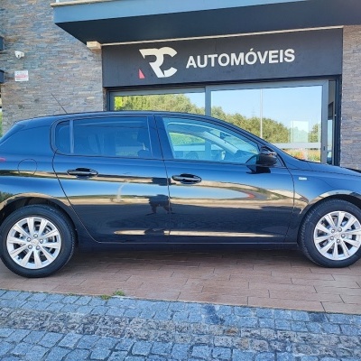 Carro preto estacionado frente a loja RC AUTOMÓVEIS