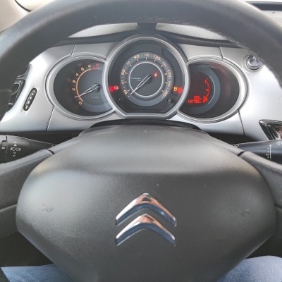 Volante preto de carro Citroën com painel de instrumentos