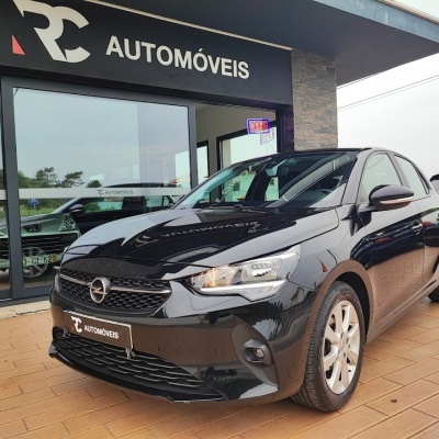 Automóvel Opel preto estacionado em frente a loja RC AUTOMÓVEIS