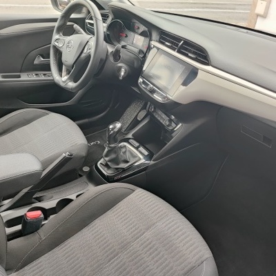 Interior de carro Opel com volante em couro preto e bancos em tecido cinzento.