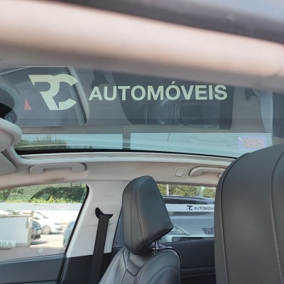 Interior de carro com banco de couro preto e teto panorâmico com reflexo