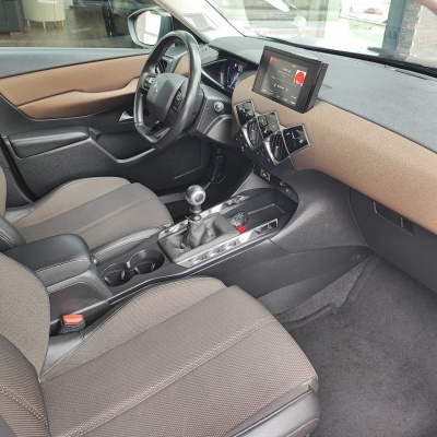 Interior de carro com assentos de tecido castanho e preto e painel com ecrã digital