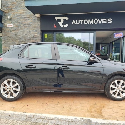 Carro preto de 5 portas em frente a loja RC AUTOMÓVEIS