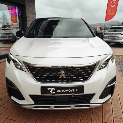 Carro Peugeot branco com grelha preta em exposição em loja de automóveis