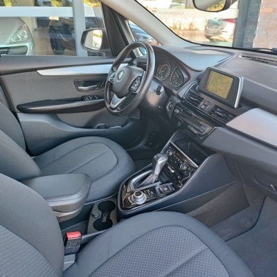Interior de carro com bancos cinza e volante preto.