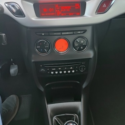 Painel central de comandos e rádio de carro com ecrã digital vermelho e alavanca de mudanças manual