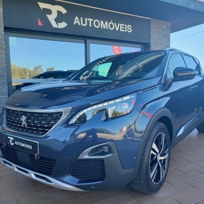 Carro SUV Peugeot azul metálico estacionado em frente à loja RC AUTOMÓVEIS
