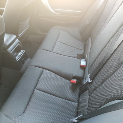 Banco traseiro de carro cinza em tecido com cintos de segurança pretos