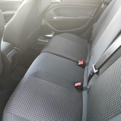 Assento traseiro de carro cinzento com padrão pied-de-poule e cintos de segurança
