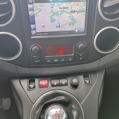 Painel de carro com navegação GPS, comandos de ar condicionado e caixa manual de velocidades.