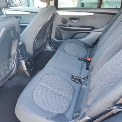 Banco traseiro de carro com estofos cinzentos e detalhes em plástico