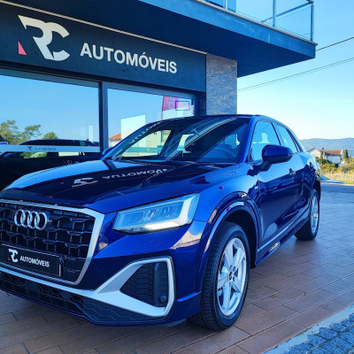 Carro Audi azul estacionado em frente a loja RC AUTOMÓVEIS