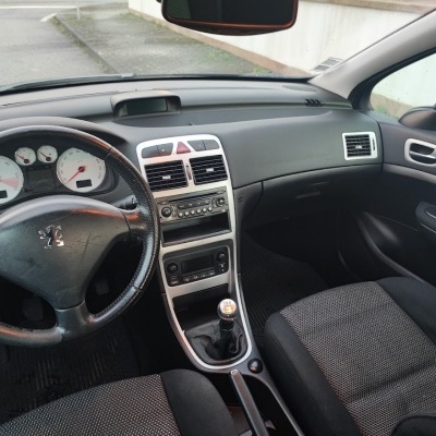 Interior de automóvel Peugeot com volante em couro e bancos em tecido cinza