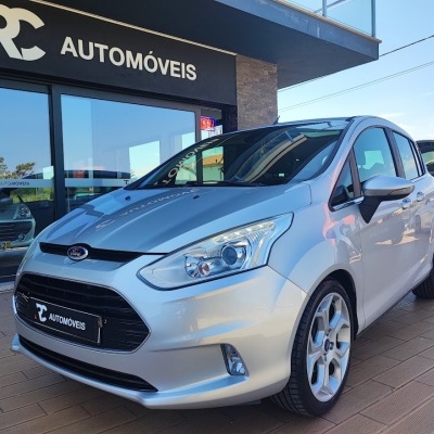 Carro Ford prateado à venda em frente a loja RC AUTOMÓVEIS.