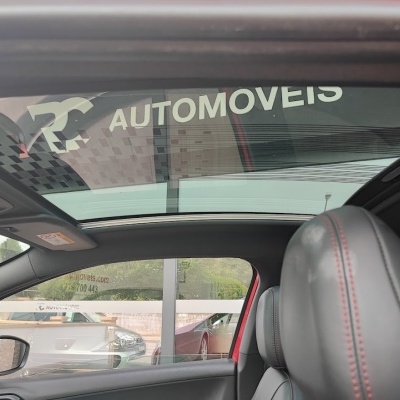 Interior de carro com banco de couro cinza escuro e teto panorâmico de vidro