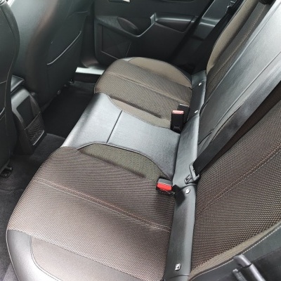 Banco traseiro de automóvel com estofos castanhos e pele sintética preta