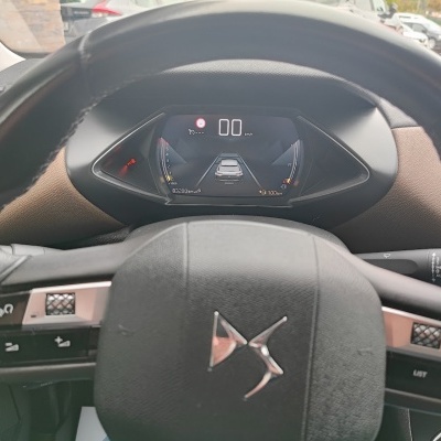 Volante de carro preto com painel digital ao fundo