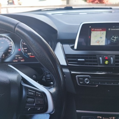 Interior de carro com volante preto, painel digital e ecrã central