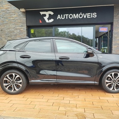 Carro SUV preto em frente a loja RC Automóveis com sinal de aberto
