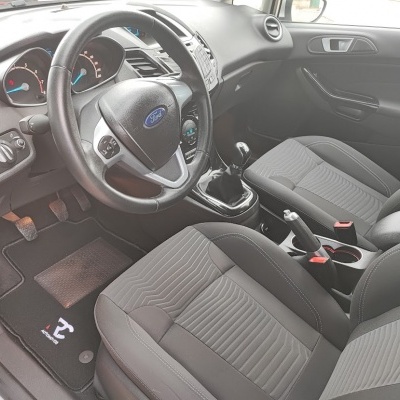 Interior de carro Ford com bancos cinza e volante preto.