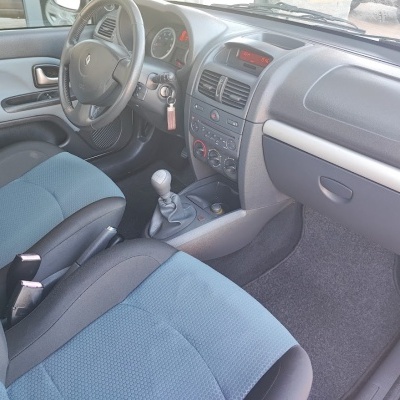 Interior de carro Renault com bancos azuis e pretos e volante em couro preto