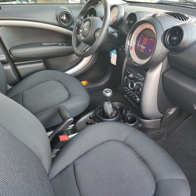 Interior automóvel com bancos em tecido cinza e painel central com mostrador digital.