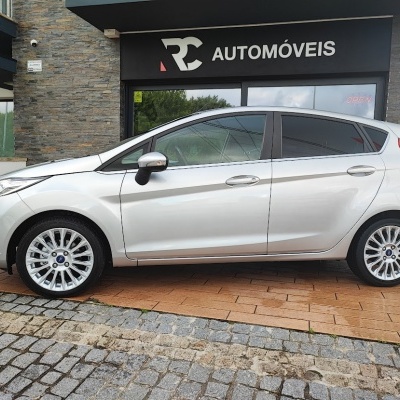 Carro branco estacionado junto a loja RCC AUTOMÓVEIS