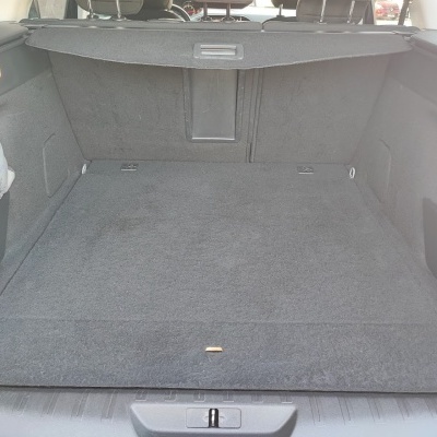 Porta-malas de carro cinzento com proteção e saco branco na lateral
