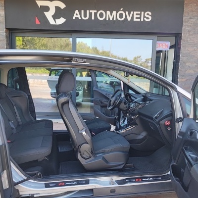 Interior de carro prateado com portas abertas em frente à loja RC AUTOMÓVEIS