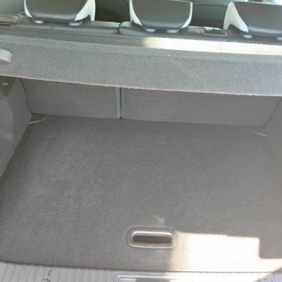 Bagageira de carro com revestimento cinzento e encostos de cabeça atrás