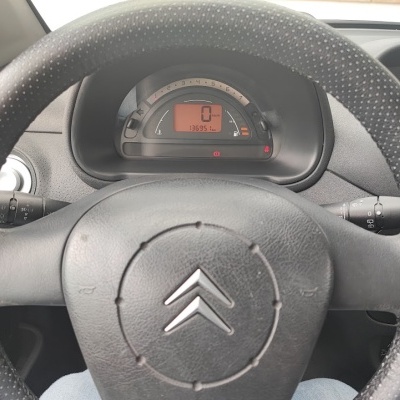 Volante preto de Citroën com painel digital e relógio no tablier