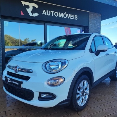 Carro Fiat branco em frente a loja RC Automóveis