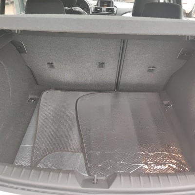 Porta-bagagens de carro com tapetes prateados e acabamento em tecido cinzento