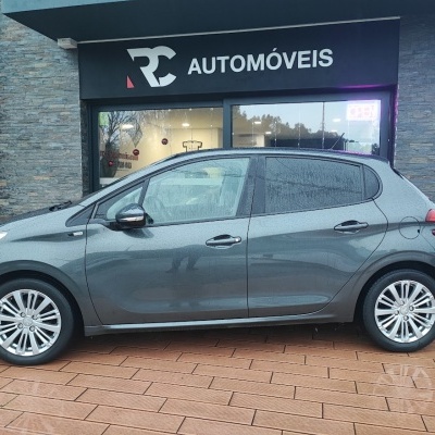 Carro cinzento metálico de 5 portas em frente à loja RC AUTOMÓVEIS