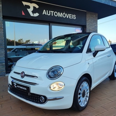 Carro branco Fiat 500 em frente a loja RC AUTOMÓVEIS